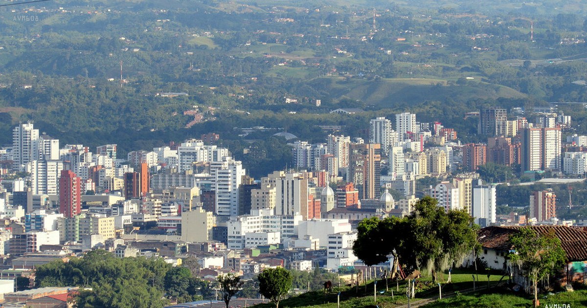 Wide view across the city of Pereira, Colombia, with dense buildings and green hills beyond.