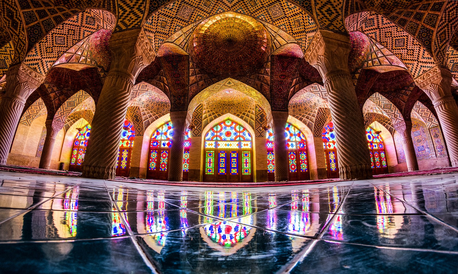 Colourful stained-glass windows, patterned arches and columns inside the Nasir ol-Molk Mosque in Shiraz.