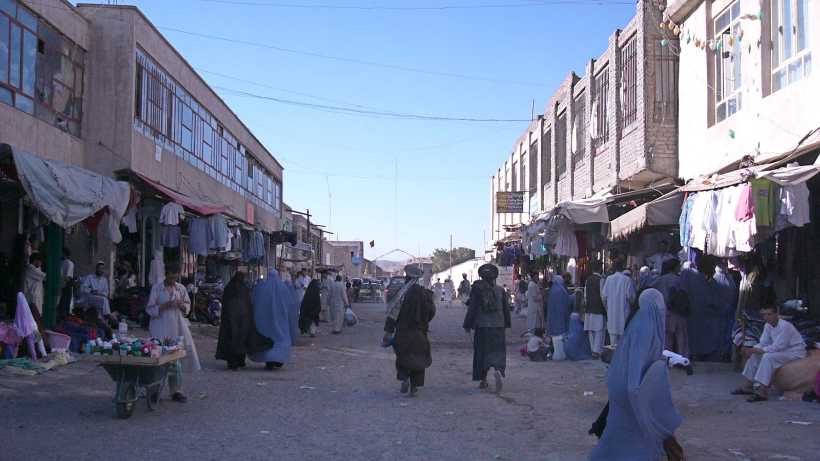 Women walk through a market street in Afghanistan.
