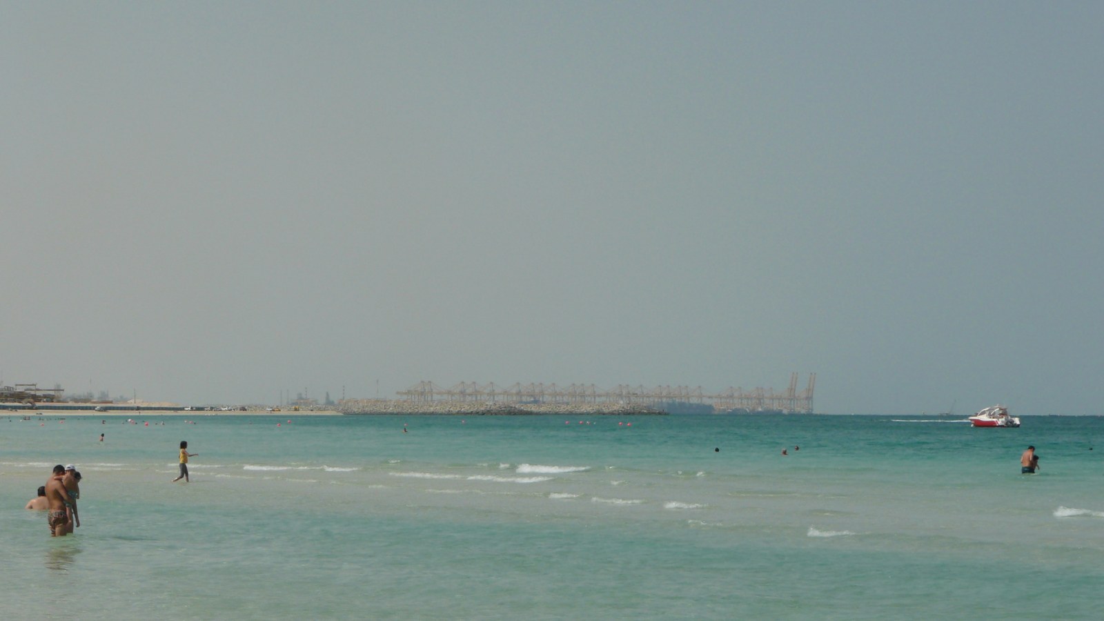 Cargo vessels and small trading boats move through a harbour in Dubai.