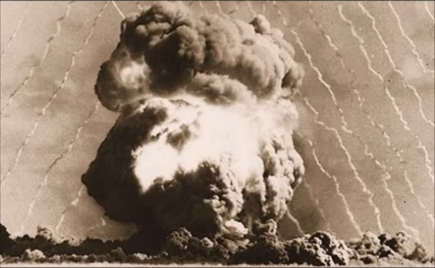 Image of a nuclear detonation forming a bright mushroom cloud.