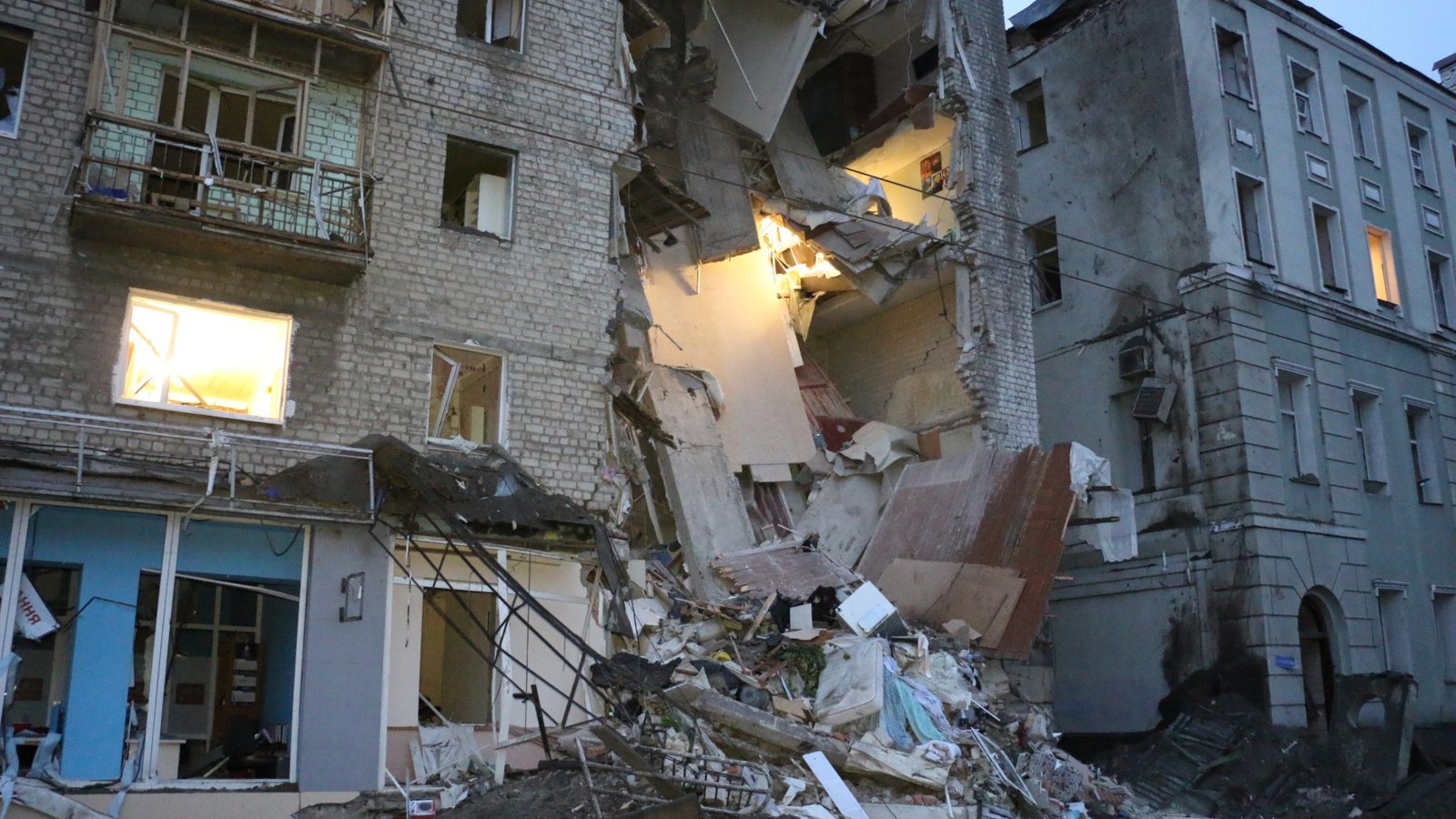 Damaged urban building in Ukraine with emergency workers nearby