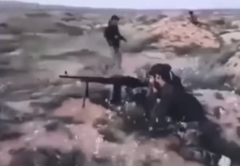 A fighter of Liwa Zainebiyoun firing at an ISIS position in Syria. (2017)