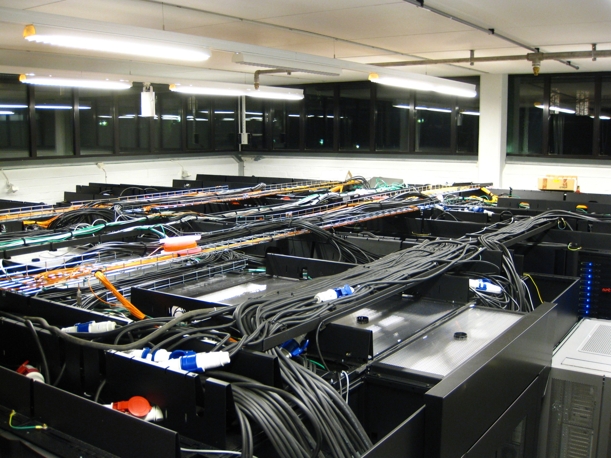 Rows of computer servers and network cables inside a data-centre server room.