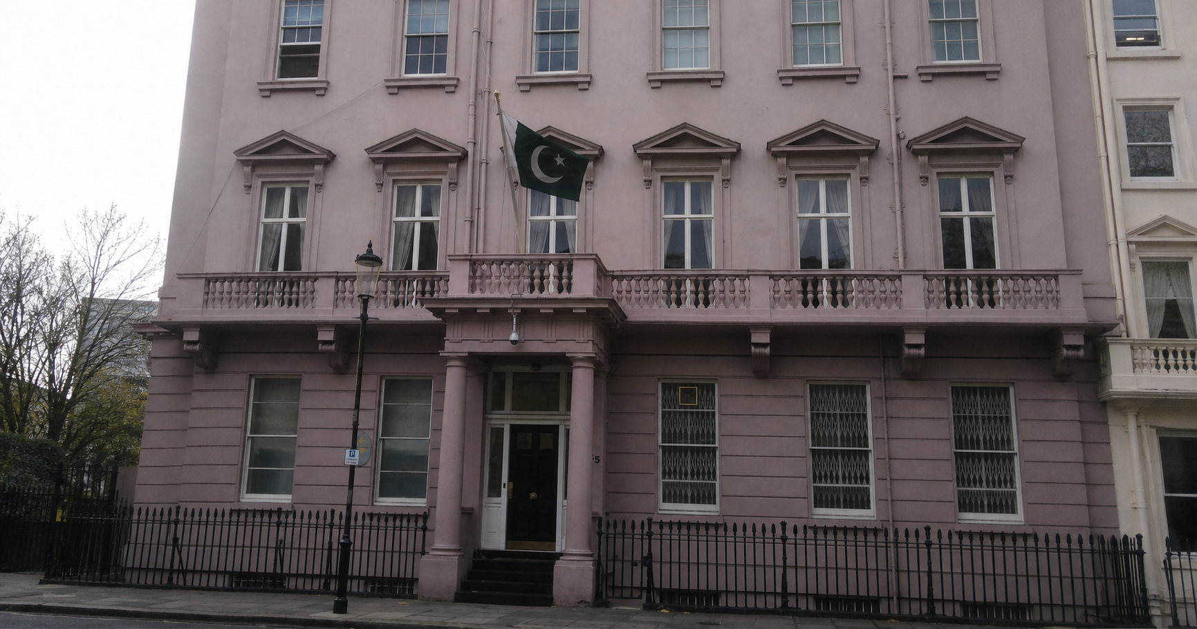 The Pakistan High Commission building in London with the Pakistani flag visible outside.