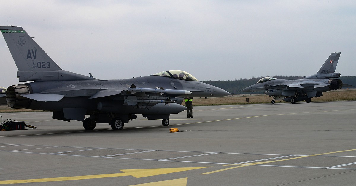 A Polish F-16 fighter jet taxiing past a United States Air Force F-16 at Lask Air Base in Poland.