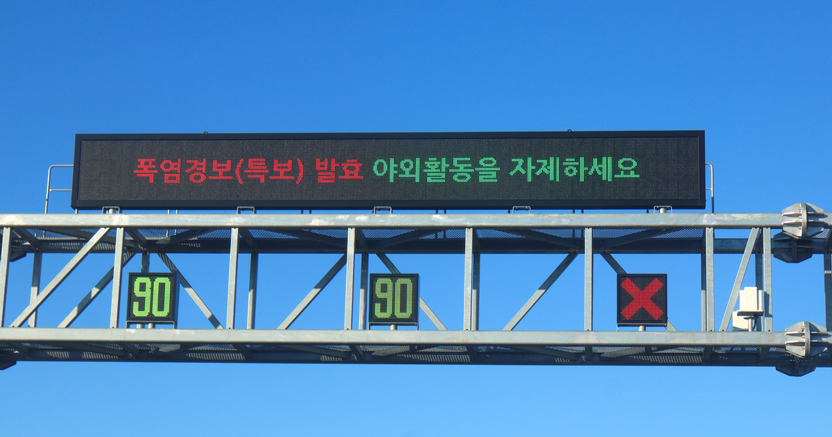 Electronic motorway information board in South Korea displaying a Korean-language heatwave warning.