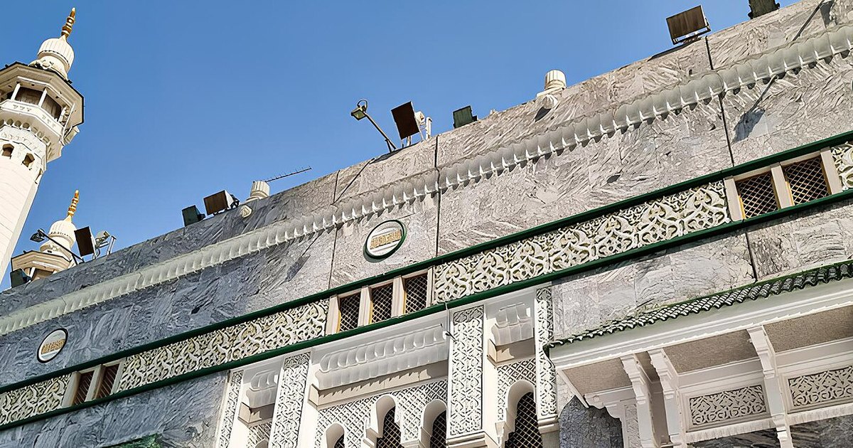 Wide exterior view of the Grand Mosque of Makkah and surrounding city buildings.