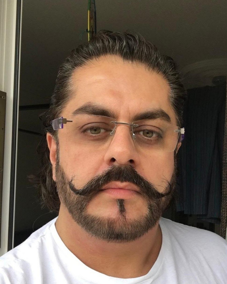A recent portrait of Mehran Marri Baloch, wearing glasses and a white shirt.