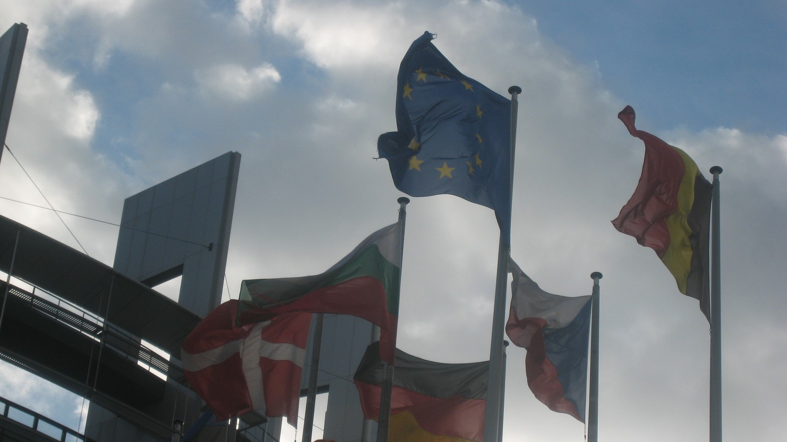 The European Parliament building in Strasbourg beneath a partly cloudy sky.