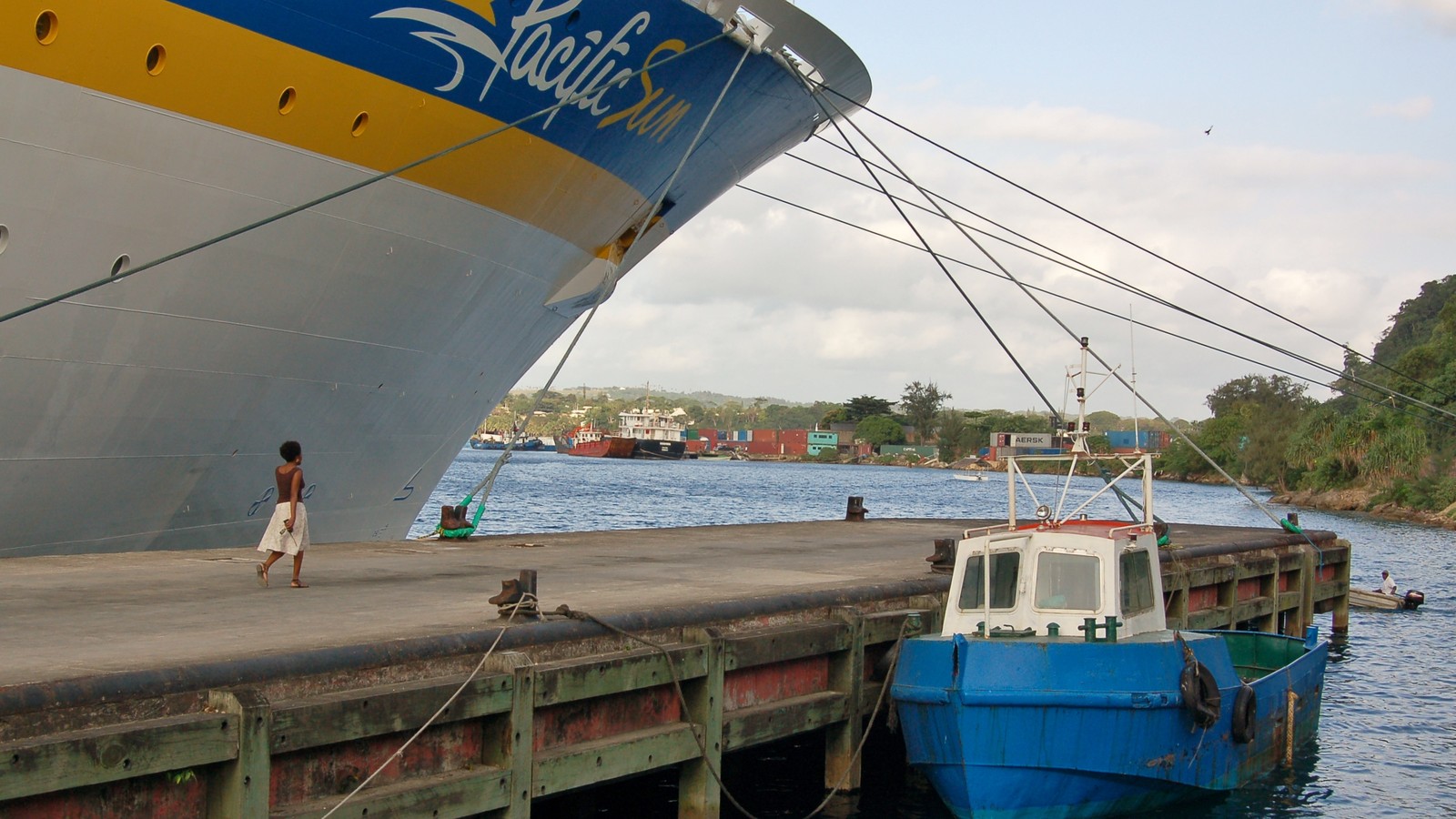 A passenger ferry travelling through coastal waters near a Pacific island.