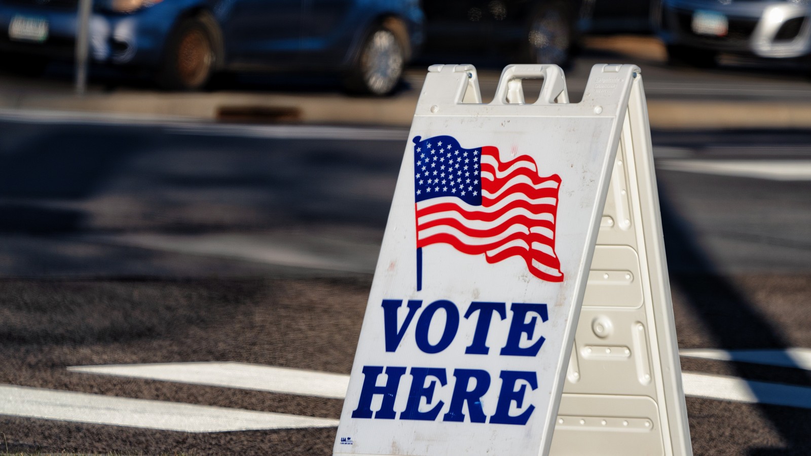 An American voter approaches a polling-place entrance beneath a sign directing voters.